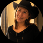 Rachel smiling outdoors wearing a cowboy hat